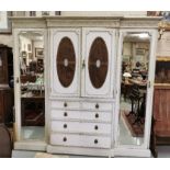 Maple & Co. white painted 4-door wardrobe, decorative cornice above 2 central oval cane work &