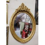 Ornate Oval-Shaped Gilt Framed Wall Mirror with decorative borders and finial, 116cm h x 78 cm h