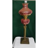 Early 20th C brass Oil Lamp with cranberry colour glass shade & reservoir, Corinthian column, 75cm