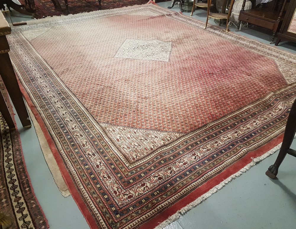 A large Persian design Carpet, red ground with stylized blue decoration, multiple borders, 1960s,