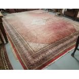 A large Persian design Carpet, red ground with stylized blue decoration, multiple borders, 1960s,