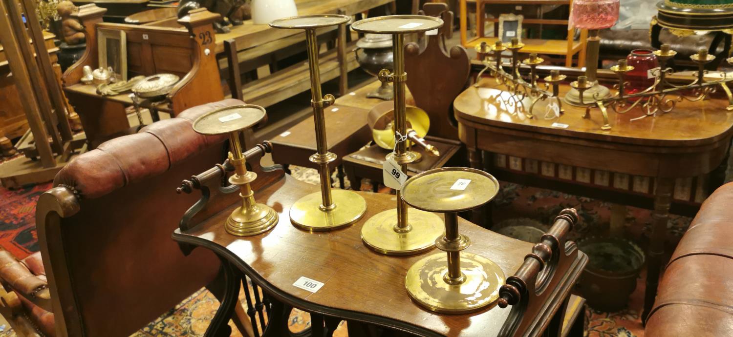 Four extendable brass candlesticks.