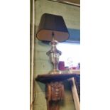 Brass table lamp with black lampshade.