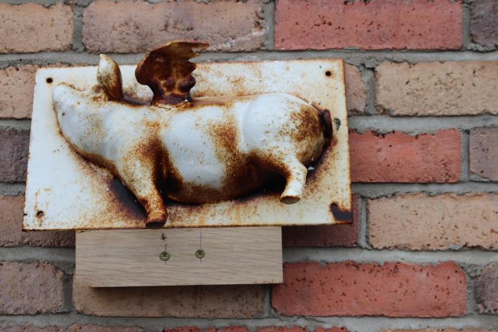 Cast iron wall plaque in the form of a pig.