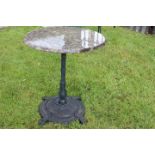 Art Deco style cast iron table with circular marble top.