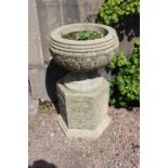 Pair of circular sandstone planters on plinths.