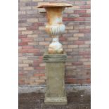 Cast iron garden urn on sandstone base.