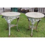 Two decorative cast iron tables with circular marble tops.