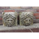 Pair of stone heads in the form of water features.