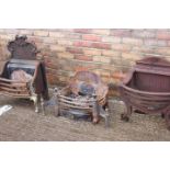 Three decorative cast iron free standing fire grates.