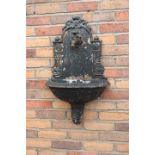 Cast iron wall plaque water feature.