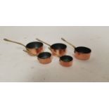 Set of five copper and brass sauce saucepans.