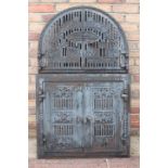 Decorative cast iron arched furnace doors.