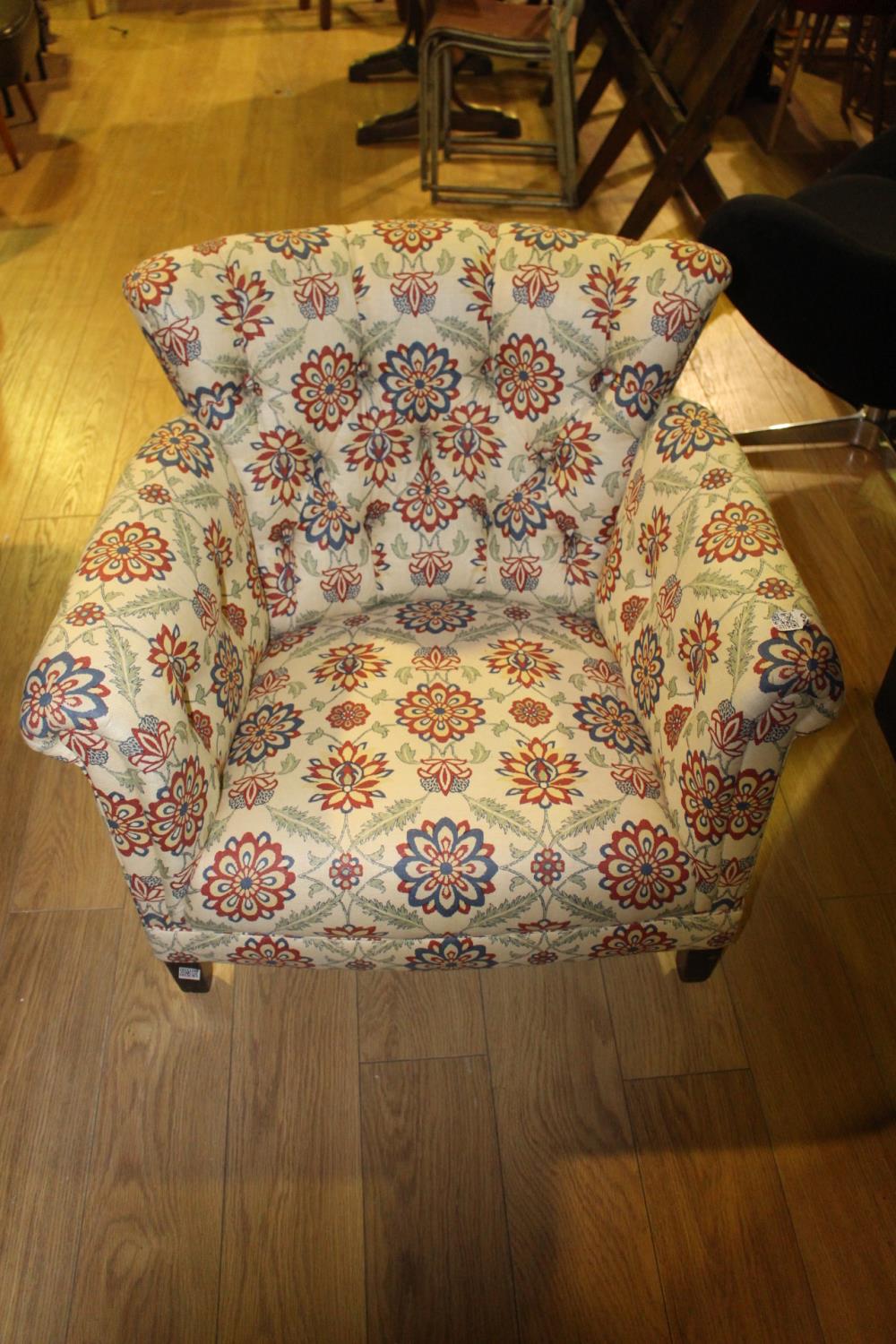 Deep buttoned back floral tub chair.