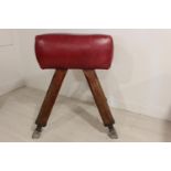 Early 20th C. pommel horse with red leather seat.