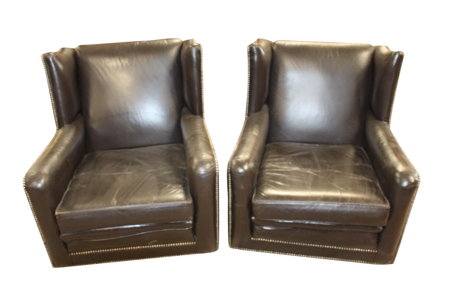 Pair of leather wing back easy chairs.