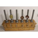 Set of six beer pulls on oak stand.