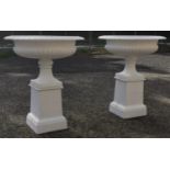 Pair of exceptional quality cast iron garden urns on plinths in the Georgian style .