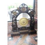 Oriental gong in hand carved wooden frame .