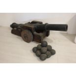 Wooden and fibre glass model of a cannon and cannon balls.