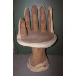 Solid wood carved chair in the form of a hand.