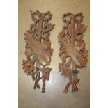 Pair of carved mahogany wall hangings.
