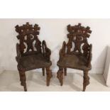Rare pair of hand carved black forest arm chairs.