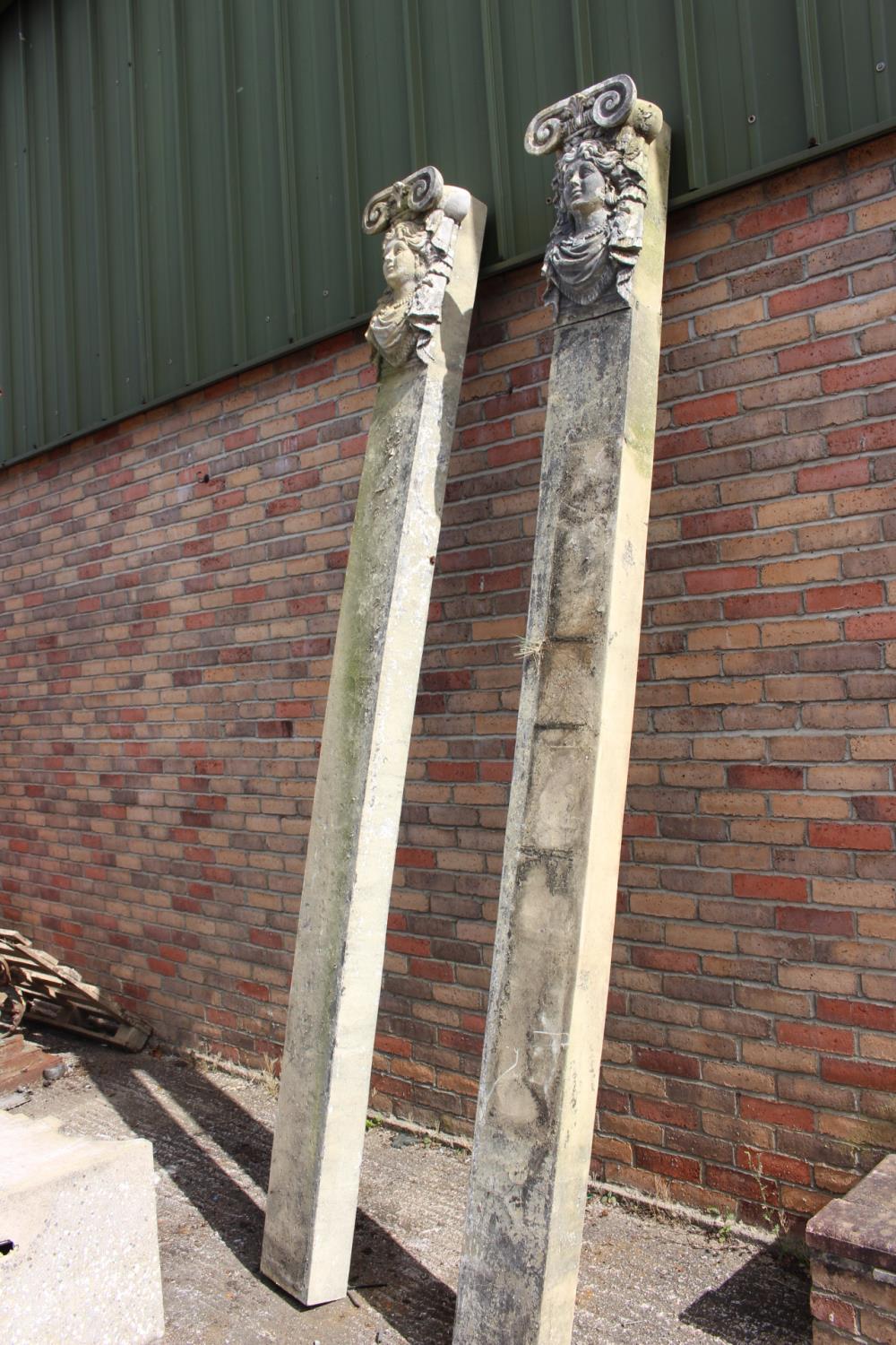 Pair of resin columns decorated with masks.