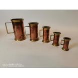 Set of five graduating copper and brass measures.