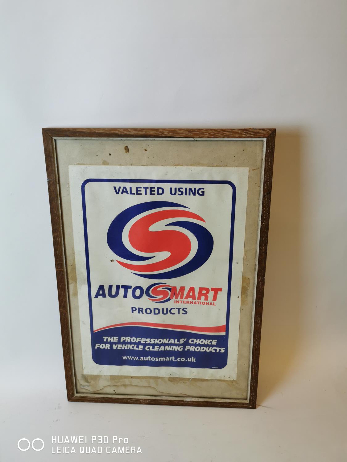 Framed AutoSmart International Products advertising sign.