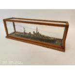 Model of a battle ship mounted in a glazed case.