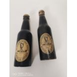 Pair of Guinness advertising bottles in the form of clothes brushes.