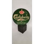 Circular Carlsberg Lager double sided advertisement mounted on a wooden base.