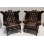 Pair of leather wingback armchairs .