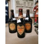 Three vintage bottles of Guinness.