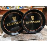 Two Guinness advertising drinks trays.