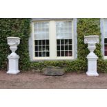 Pair of composition stone urns on stands