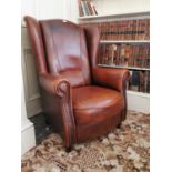 Leather upholstered wingback armchair.