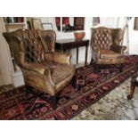 Pair of leather deep buttoned wing back armchairs.