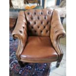 Deep buttoned leather club chair.