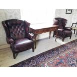 Pair of oxblood leather upholstered wing back armchairs