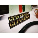 Two Guinness advertising shelf signs.