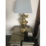 A pair of brass lamps complete with shades