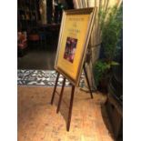 Easel complete with gold framed advertisement W 75cm H 150cm
