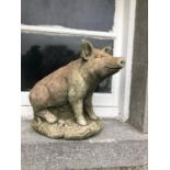 Stone sculpture of a seated pig W 40cms H 35cms D 25cms