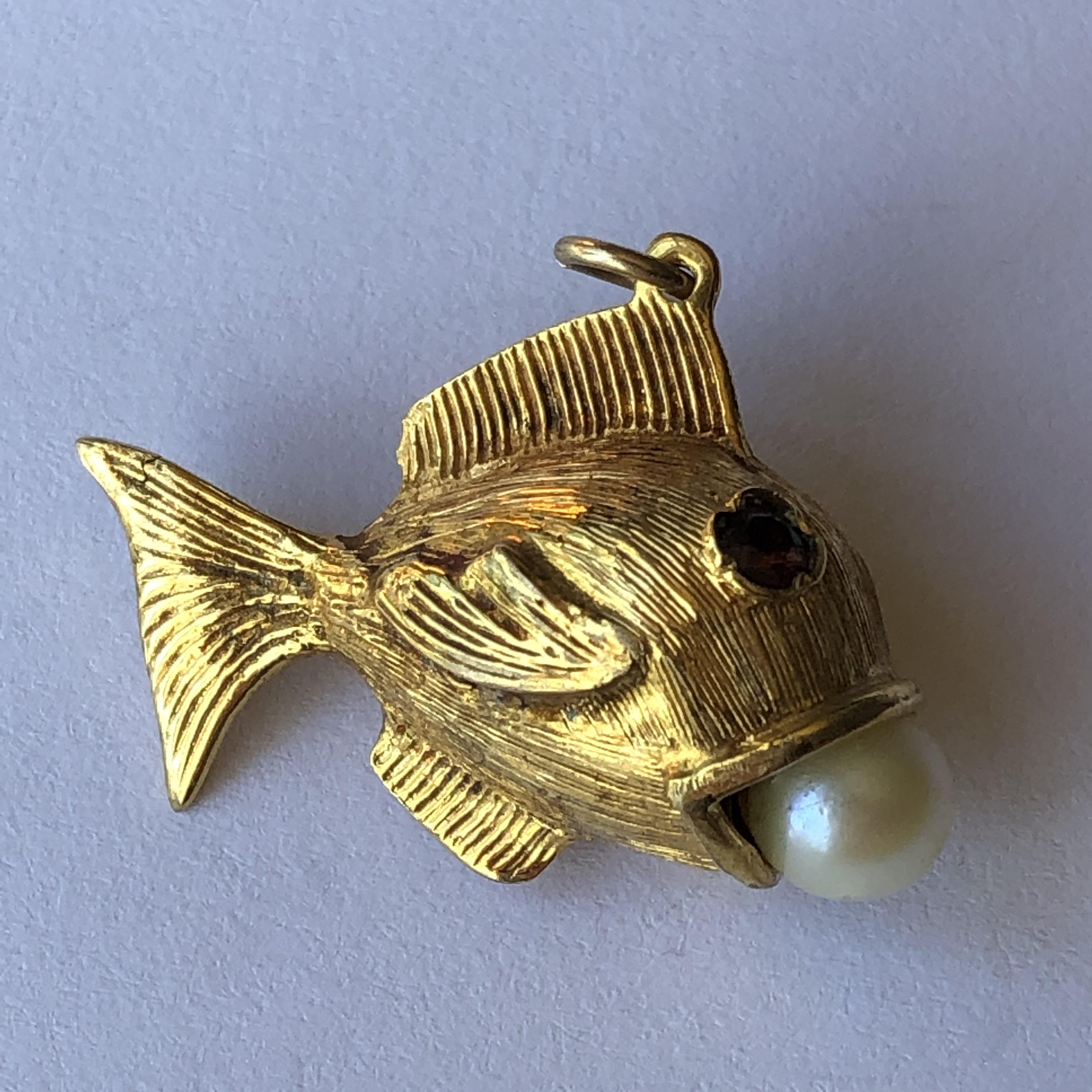 A 9CT GOLD NOVELTY CHARM IN FORM OF A FISH WITH INSET RUBY EYES AND PEARL IN ITS MOUTH 5.