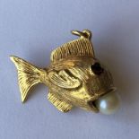 A 9CT GOLD NOVELTY CHARM IN FORM OF A FISH WITH INSET RUBY EYES AND PEARL IN ITS MOUTH 5.