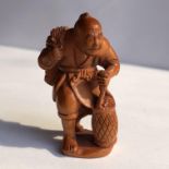 JAPANESE NETSUKE OF A FISHERMAN CARRYING A POT