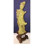CHINESE LIGHT GREEN CARVED SOAPSTONE FIGURE OF A GUANYIN ON RUSSET SOAPSTONE TRIFORM BASE 31CMH