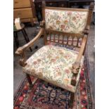 A FRENCH WALNUT CARVED AND UPHOLSTERED ELBOW CHAIR WITH LIONS HEAD ARM TERMINALS